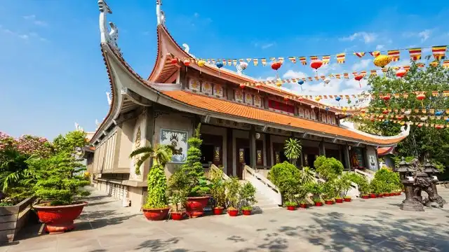 호국사 푸꾸옥: 2025년 완벽 방문 가이드 4 푸꾸옥 호국사의 붉은 지붕과 용 조각이 장식된 계단 전경.