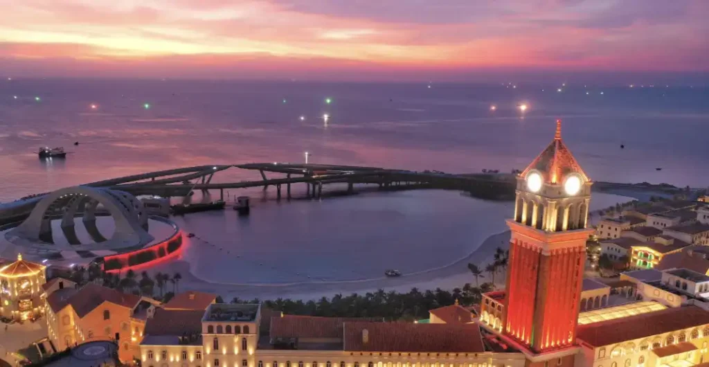 Полный Путеводитель по Сансет Таун Фукуок: Что Посмотреть и Чем Заняться. 2 Туристы гуляют по набережной Сансет Таун Фукуок среди красочных зданий.