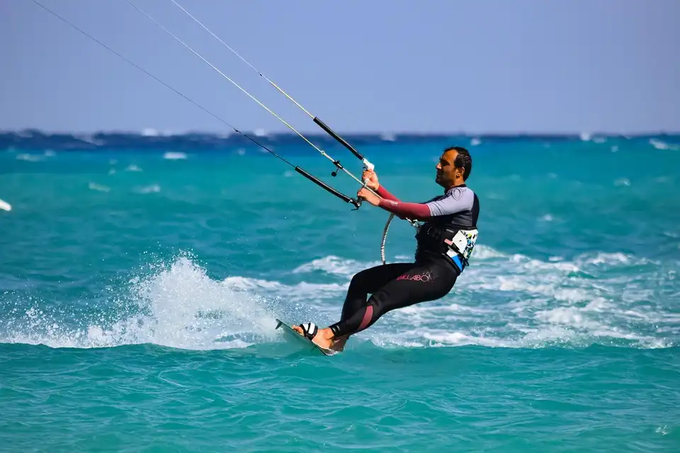 Athlete enjoying phu quoc kitesurfing on a windy beach, with waves, bright blue water, and a colorful kite soaring across the sky.